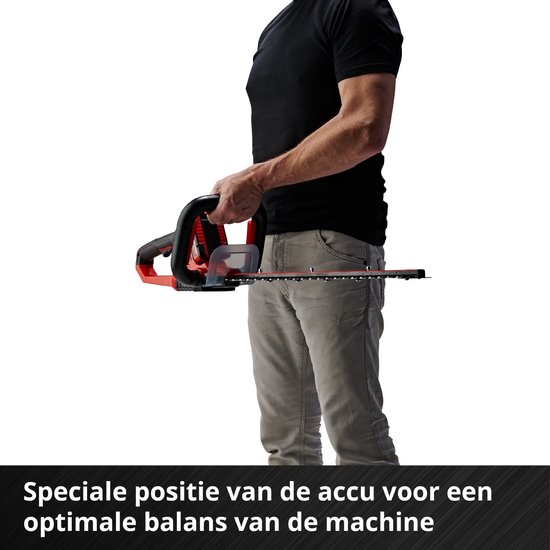 Een man met een zwarte T-shirt en grijze broek houdt een rode en zwarte heggenschaar vast. De tekst onderaan luidt 'Speciale positie van de accu voor een optimale balans van de machine'.