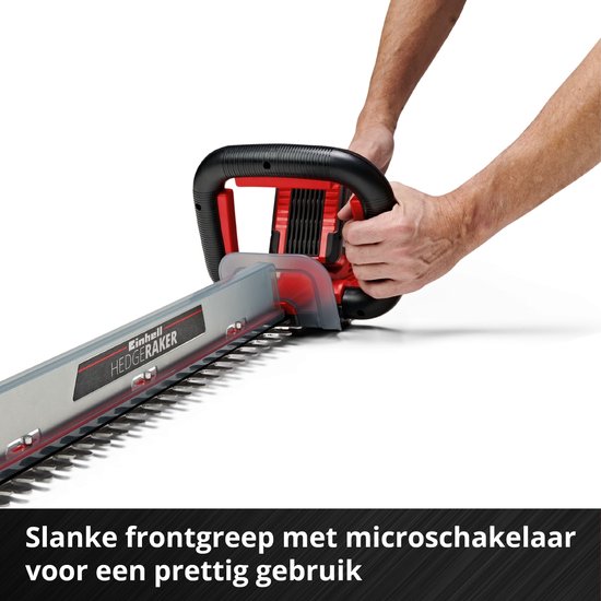 Een persoon die de rode en zwarte Einhell heggenschaar met twee handen vasthoudt.