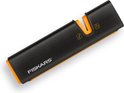 Zwarte Fiskars slijper met oranje accenten, V-vormige gleuf en symbolen.