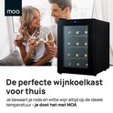 Een koppel geniet van wijn naast een zwarte MOA wijnkoelkast met 12 flessen.