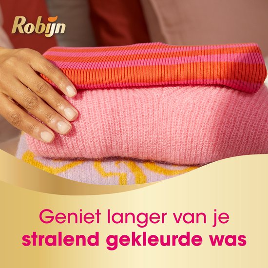 Een stapel gestreken wasgoed met een streepjes trui en roze trui. Geniet langer van je stralend gekleurde was.