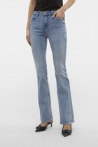 Gros plan sur un jean flare bleu clair légèrement usé, porté avec des chaussures noires.