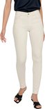 Model in een lichte, skinny jeans met rafels aan de onderkant en zwarte sandalen.