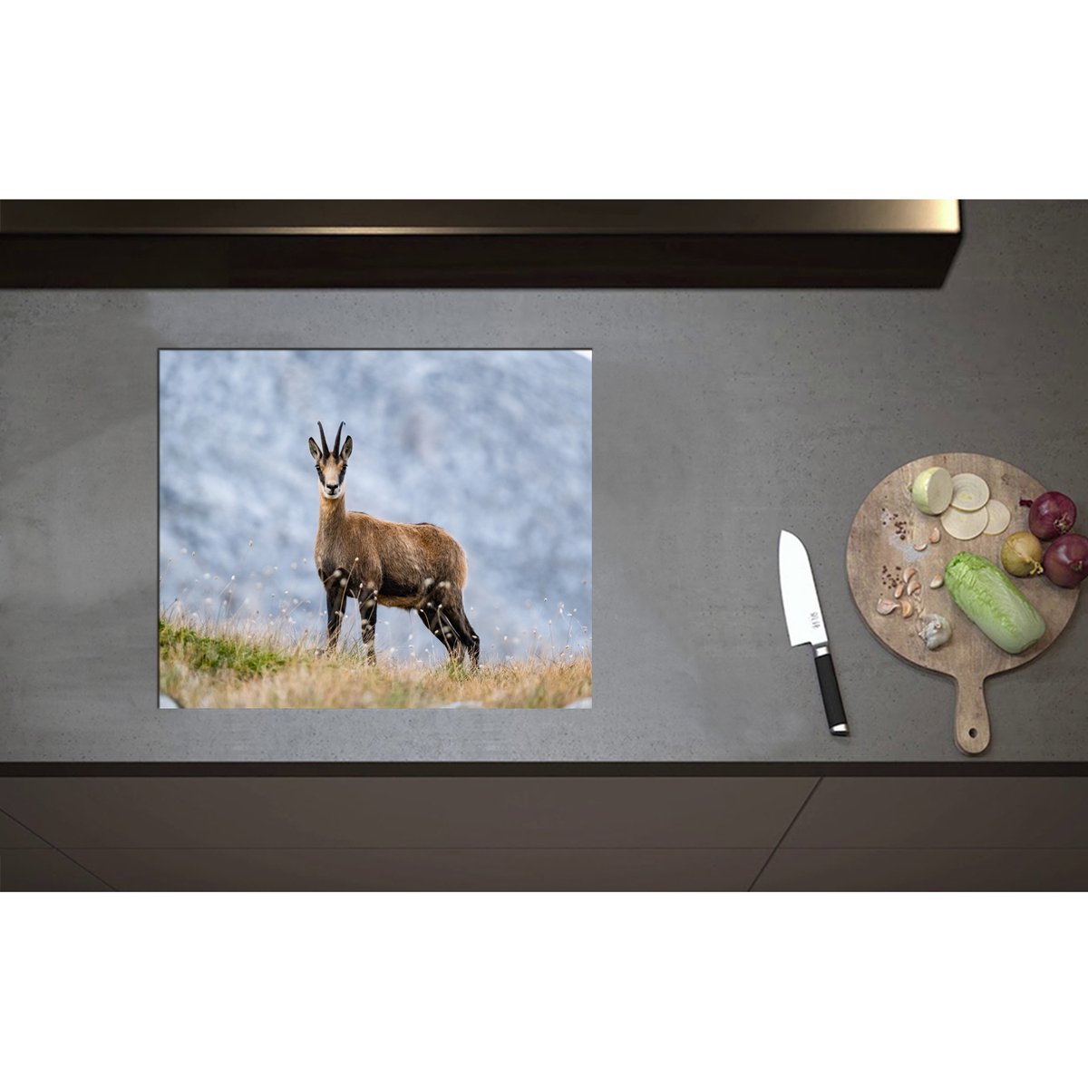 Inductieplaat Beschermer - Aankijkende Wilde Geit in het Gras aan de Rand van Bergen - 60x50 cm - 2 mm Dik - Inductie Beschermer - Bescherming Inductiekookplaat - Kookplaat Beschermer van Zwart Vinyl