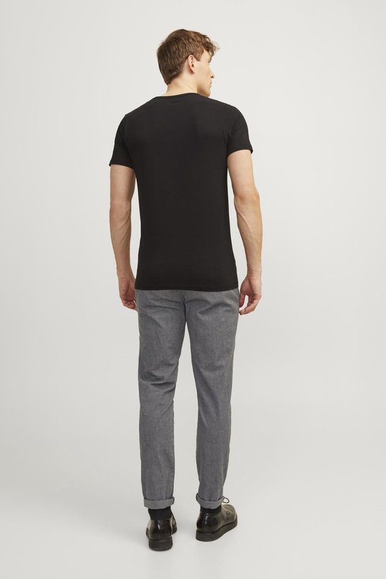Achterkant van een man met zwart t-shirt en grijze broek met fijne structuur.