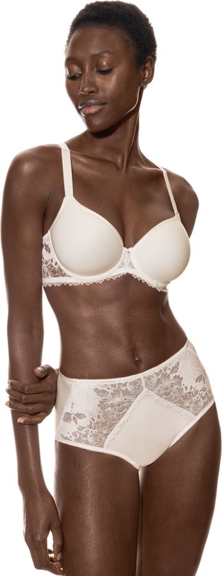 Modèle en soutien-gorge et slip blancs avec détails en dentelle. Debout, bras croisés, regardant vers le bas.