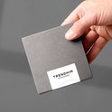 Hand houdt een grijze geschenkdoos vast.