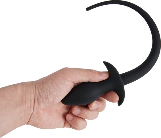 Hand houdt zwarte siliconen butt plug met een staart vast.