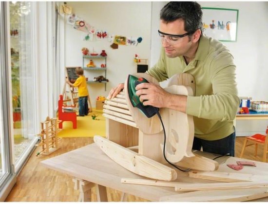 Man met veiligheidsbril schuurt een houten wipstoel met een Bosch multischuurmachine.