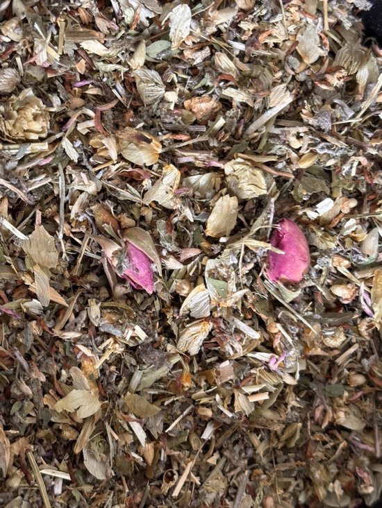 Gedetailleerde close-up van gedroogde kruiden en twee roze bloemblaadjes.
