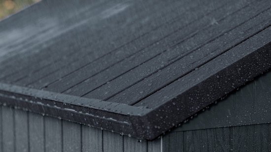 Gouttes de pluie sur le toit incliné gris d'un abri de jardin.