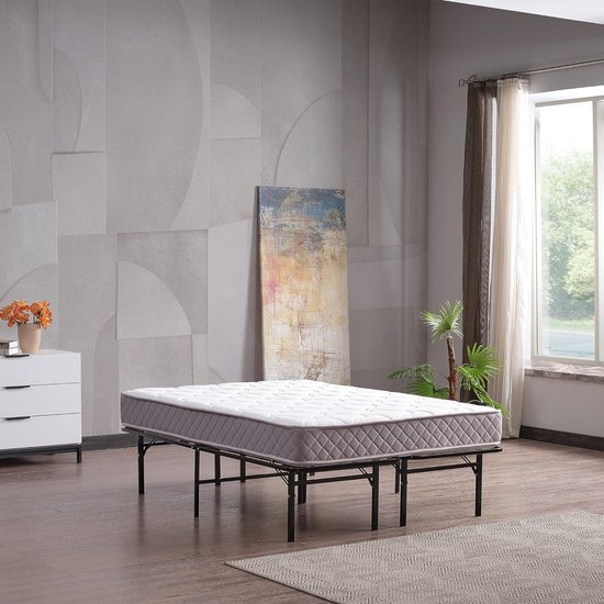 Zwart metalen bedframe met een matras met ruitpatroon.