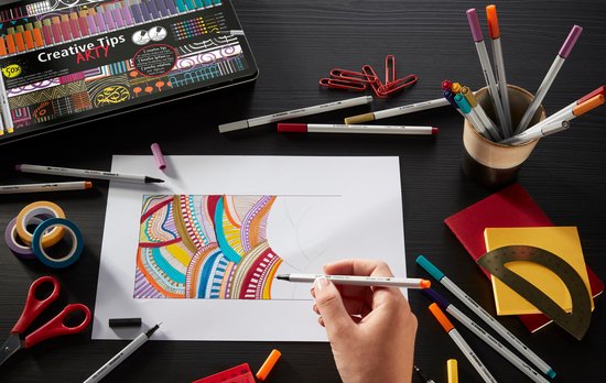 Een hand tekent een kleurrijke, abstracte lijntekening met een Stabilo fineliner.