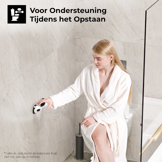Vrouw in badjas gebruikt de witte met zwarte handgreep naast een toilet voor ondersteuning bij het opstaan.