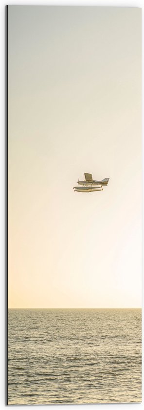 WallClassics - Dibond - Vliegtuig Vliegend boven Water met Boeien bij Lichtkleurige Lucht - 30x90 cm Foto op Aluminium (Wanddecoratie van metaal)