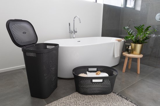 Zwarte wasmand met deksel en een ronde, grijze wasmand ernaast, in een badkamer.