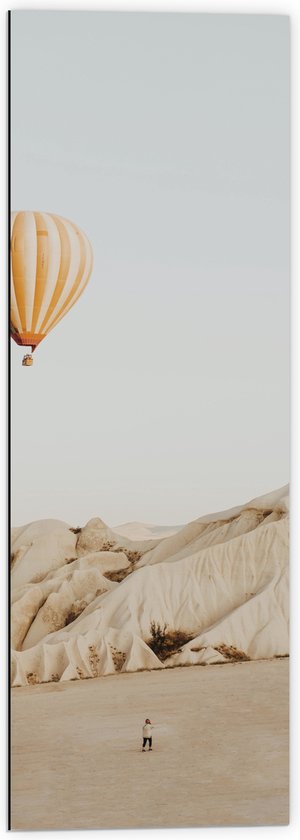 Dibond - Oranje met Wit Gestreepte Luchtballon Vliegend boven Beige Rotsen - 40x120 cm Foto op Aluminium (Wanddecoratie van metaal)