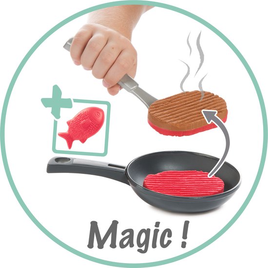 Een hand legt een speelgoedburger op een speelgoedkoekenpan boven een speelgoedfornuis. Een speelgoedvisje is zichtbaar in een kader. Tekst: Magic!