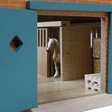 Houten paardenstal interieur, witte paard in een box, hooibalen en kratten.