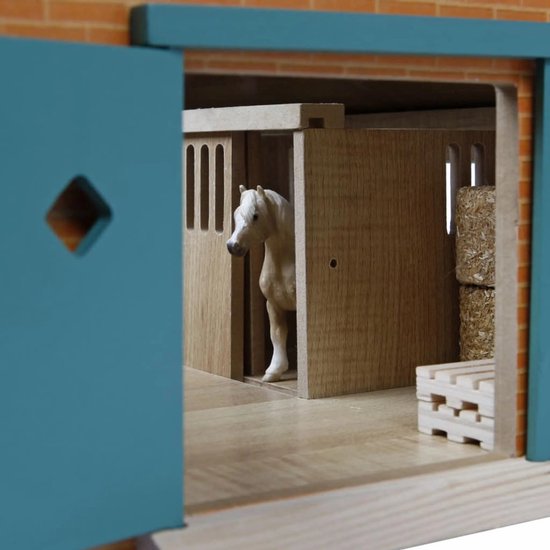 Houten paardenstal interieur, witte paard in een box, hooibalen en kratten.