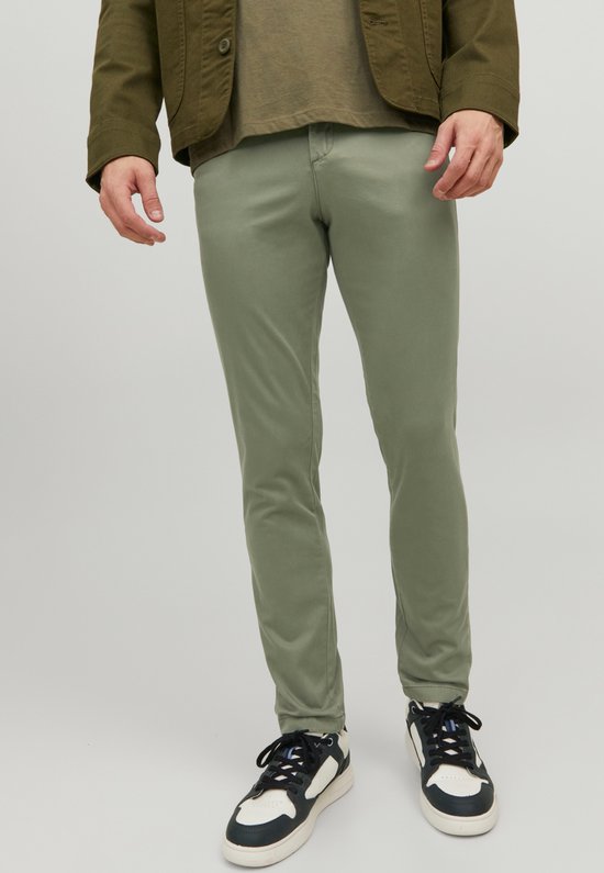 Man met smalle, lichtgroene broek en groen jack.