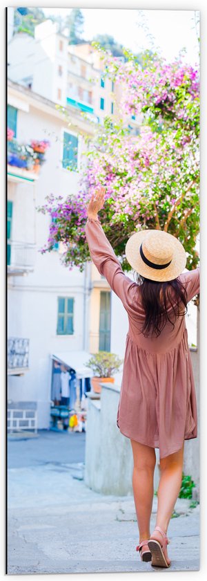 Dibond - Juichende Vrouw met Hoed bij Roze Bloemenstruik in Dorpsstraatje - 40x120 cm Foto op Aluminium (Met Ophangsysteem)