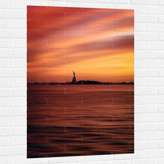 WallClassics - Muursticker - Vrijheidsbeeld in New York van Ver met Zonsondergang - 80x120 cm Foto op Muursticker