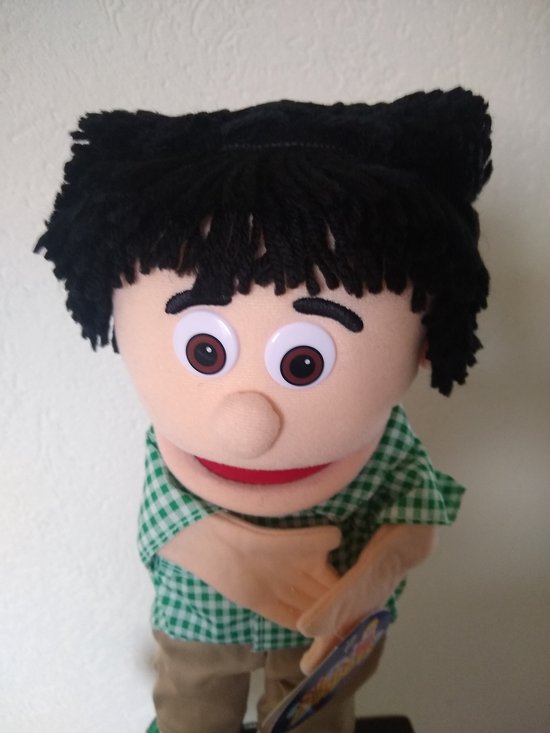 Handpop Kennie met zwarte haren, groene geruite blouse, beige broek. "Silly Puppets" logo zichtbaar.