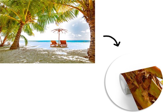 Chaises longues entre les palmiers sur une plage de Bali fotobehang