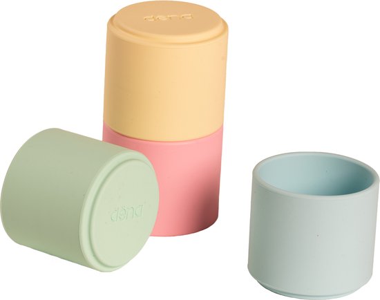 Drie Dëna stapelbekers in pastelkleuren: geel, roze en lichtgroen. Twee bekers met deksel, één open.
