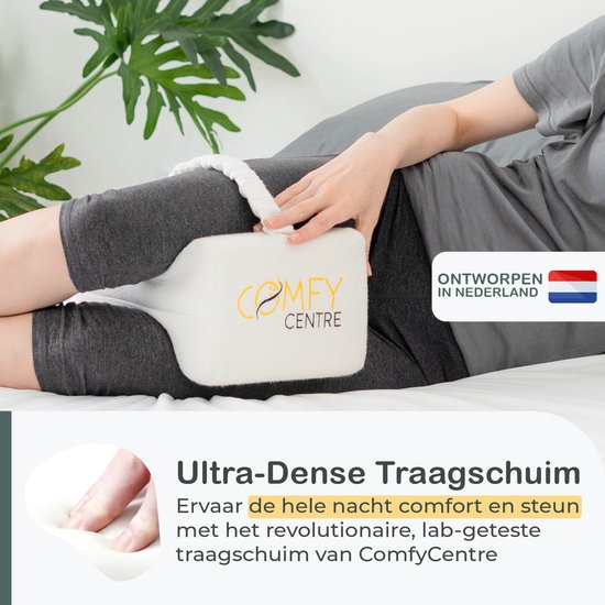 Comfy Centre kniekussen met band tussen de benen van een vrouw op bed, 'Ontworpen in Nederland'.
