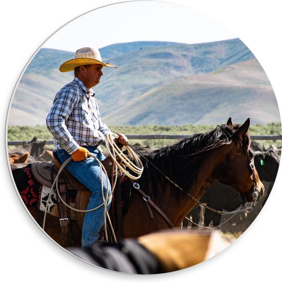 PVC Schuimplaat Muurcirkel - Cowboy op zijn Paard tussen Kudde bij Bergen - 30x30 cm Foto op Muurcirkel (met ophangsysteem)