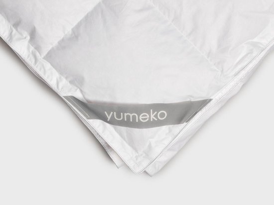 Gedetailleerd beeld van de hoek van een wit dekbed met een grijs label waarop 'yumeko' staat.
