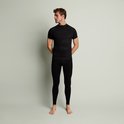 Man met zwarte thermoshirt en thermobroek, zijaanzicht.