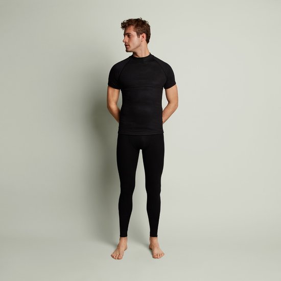 Man met zwarte thermoshirt en thermobroek, zijaanzicht.