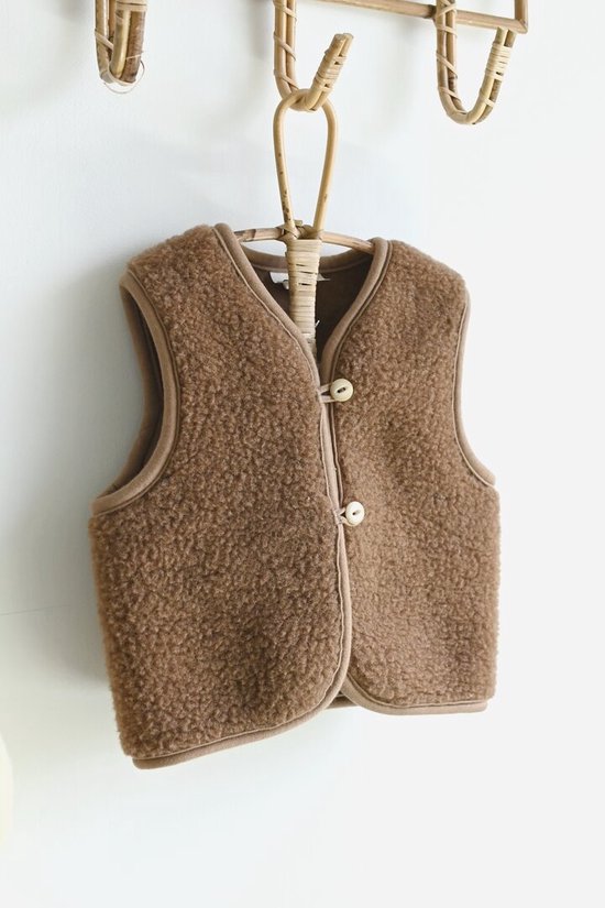Bruine teddy vest met beige bies en knoopsluiting.