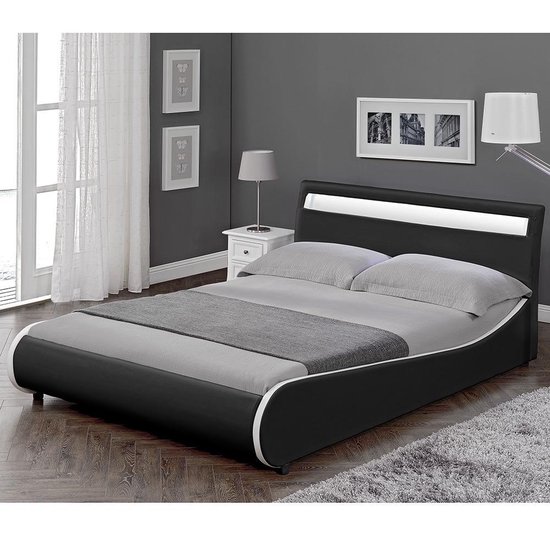 Cadre de lit noir avec tête de lit courbée, éclairage LED blanc, accents argentés et linge de lit gris dans une chambre.