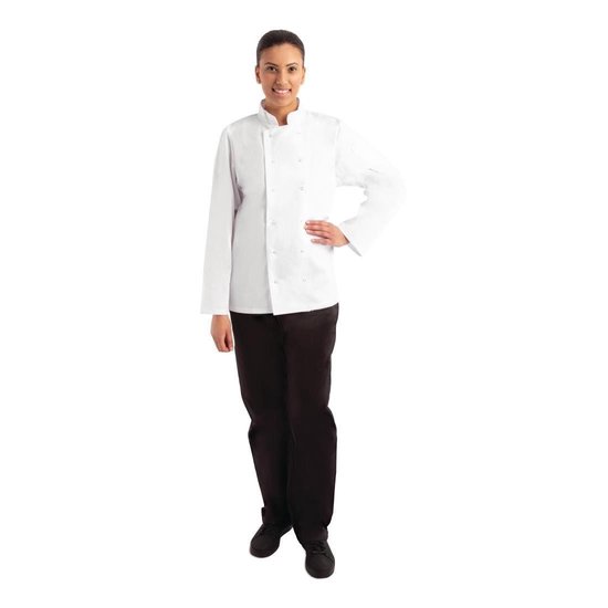 Vrouw in een witte koksbuis met lange mouwen en zwarte broek, hand op de heup.