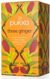 Pukka three ginger thee verpakking met oranje achtergrond en afbeeldingen van gemberbloemen en bladeren.