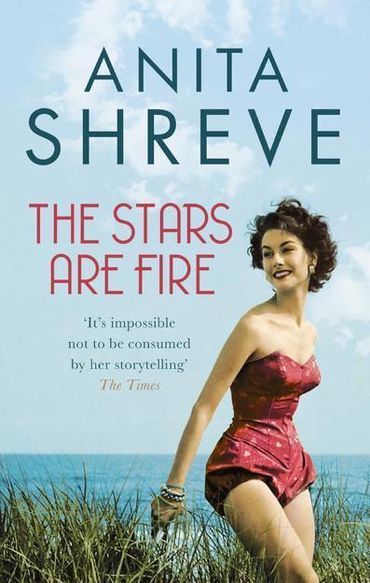 Boekcover van 'The Stars Are Fire' van Anita Shreve. Vrouw in rood badpak bij de zee.