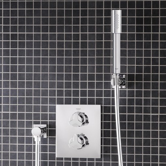 Chroomkleurige douchekraan met twee grote ronde knoppen en een vierkante handdouche.