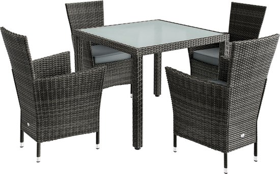 Un ensemble de jardin pour quatre personnes comprenant une table en verre et quatre chaises en polyrotin gris.