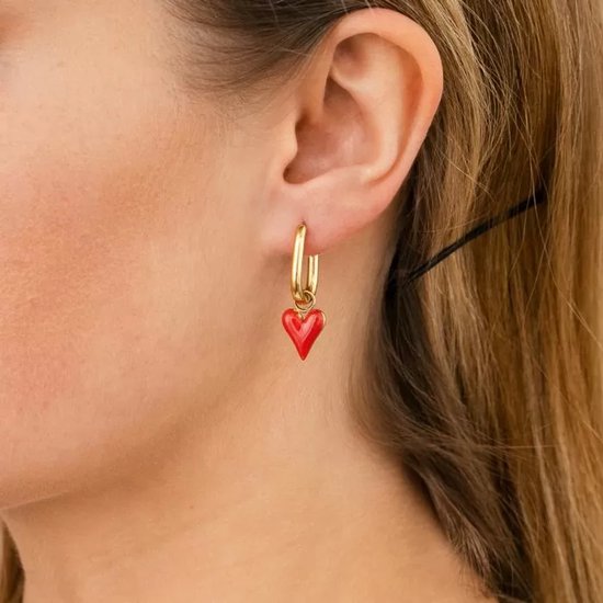 Gouden oorbel met een rood emaille hartje als hanger.