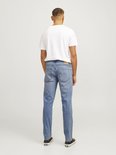 Man met rug naar de camera in lichtblauwe jeans en wit T-shirt.