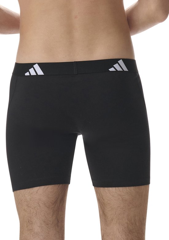 Zijzicht van zwarte Adidas boxer briefs met witte Adidas logo's op de zwarte tailleband.