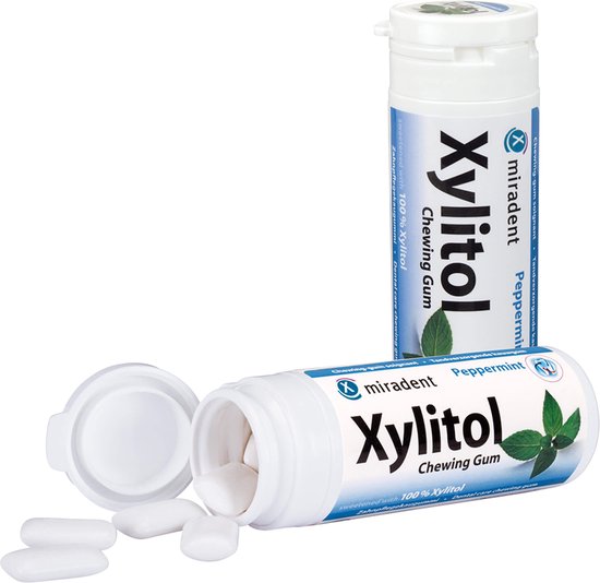 Witte Miradent Xylitol kauwgom met pepermunt smaak. Twee potjes, één open met stukken eruit.