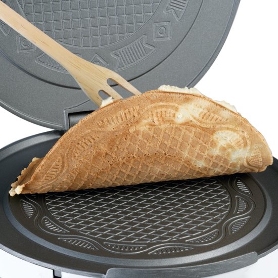 Houten spatel met een goudbruine, gevouwen wafel met ruitpatroon uit een wafelijzer.