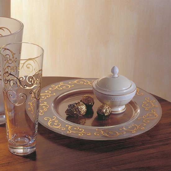 Sucrier crème avec couvercle blanc sur une assiette décorée avec du chocolat.
