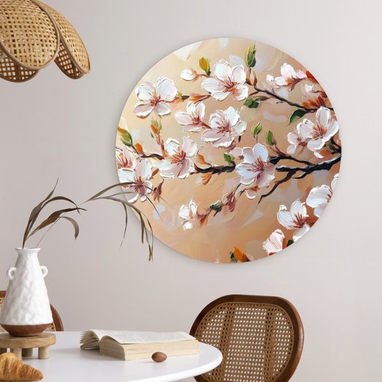 Wandcirkel met schilderachtige roze bloesemtakken, hangend aan een muur boven een eettafel.