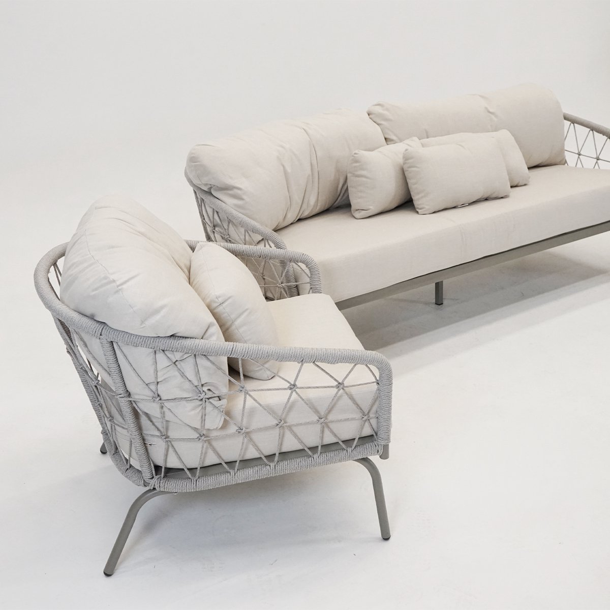 Driedelig loungeset met comfortabele kussens in natuurlijke tinten.
